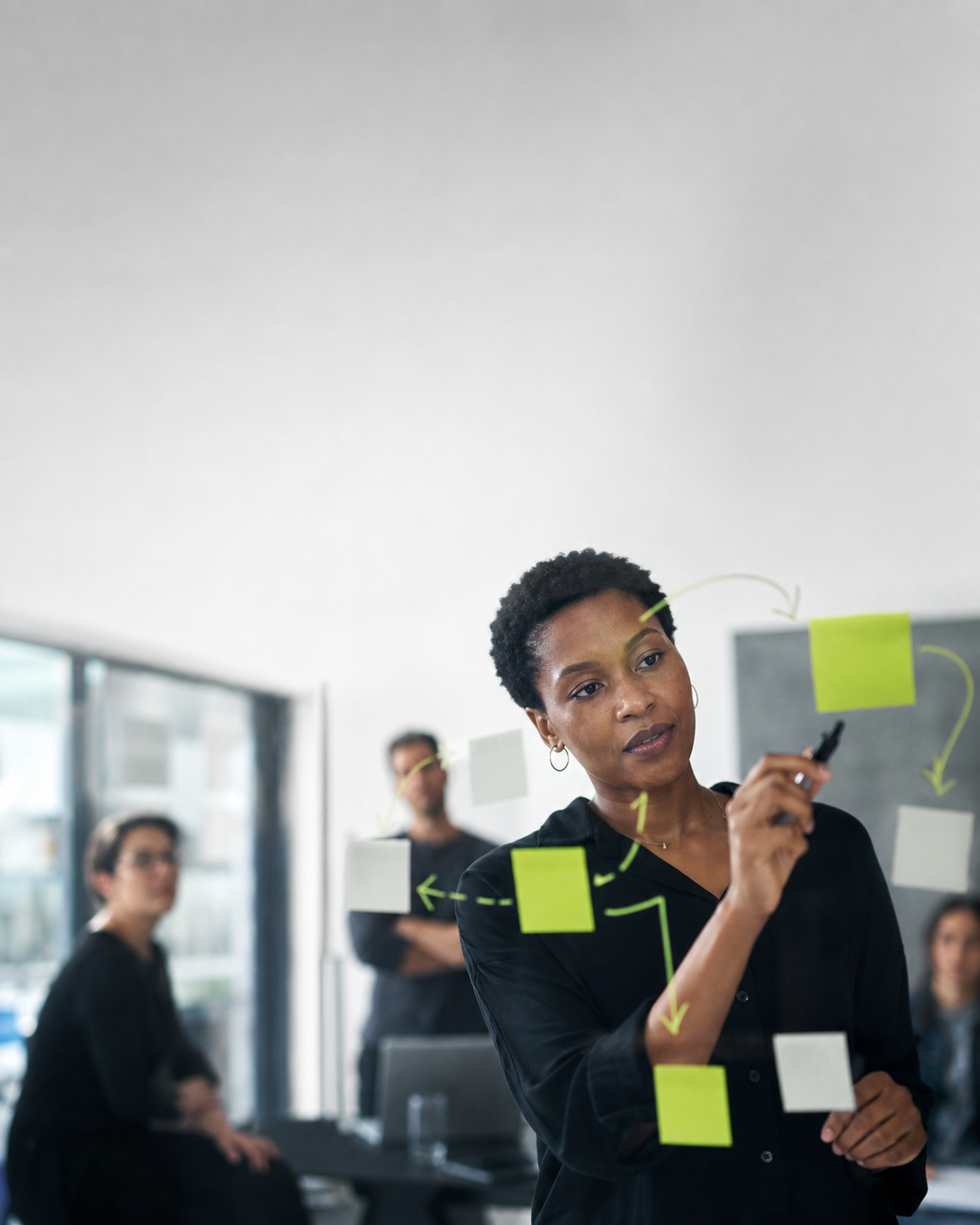 Operations lead mapping workflow handoffs on a glass wall
